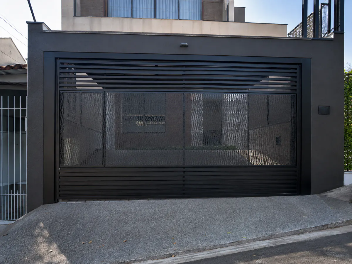 Portão de garagem em aço perfurado instalado em residência de Osasco